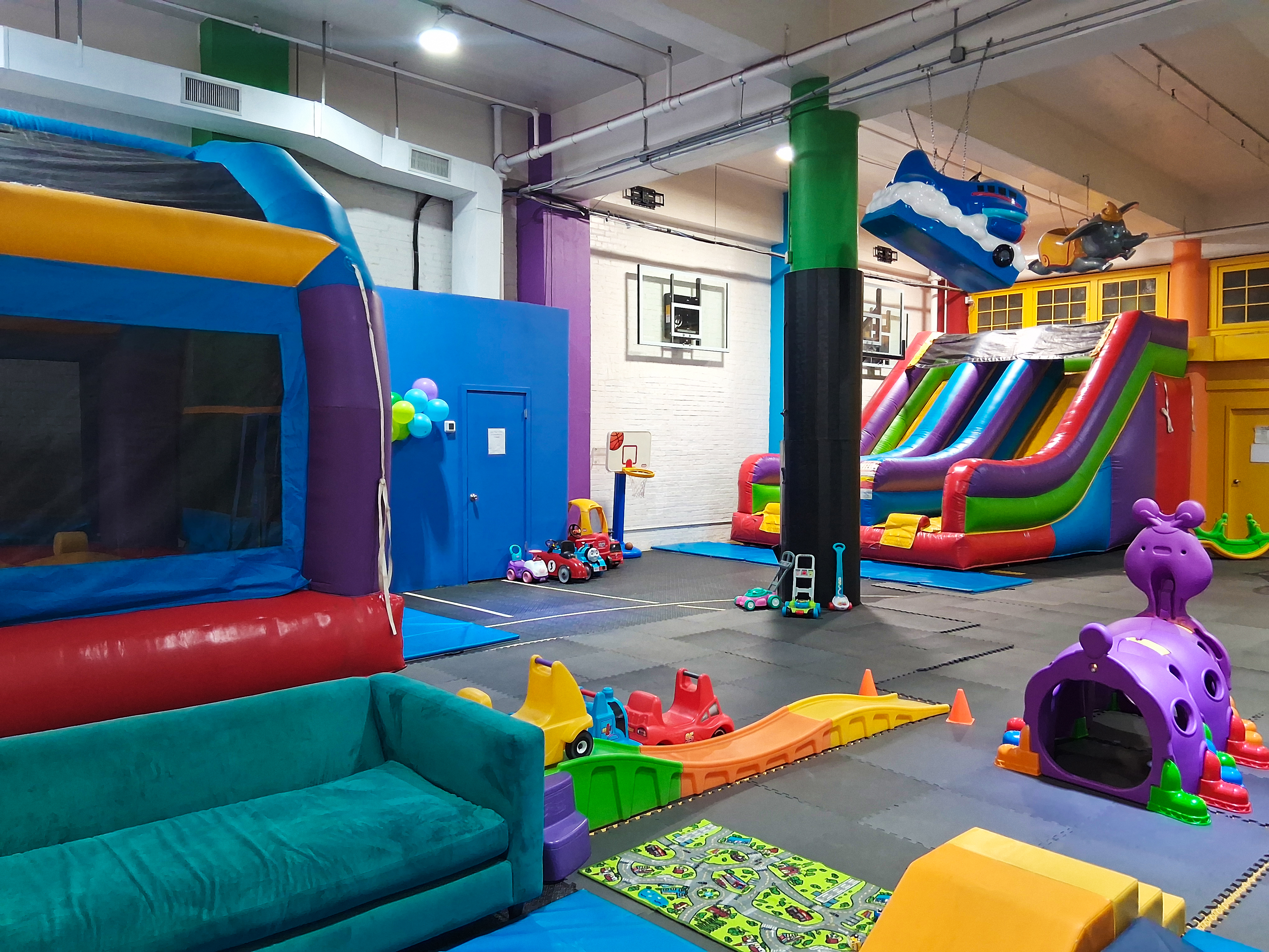 The main room at 424 Play Factory with bounce houses, slides, and various toys.