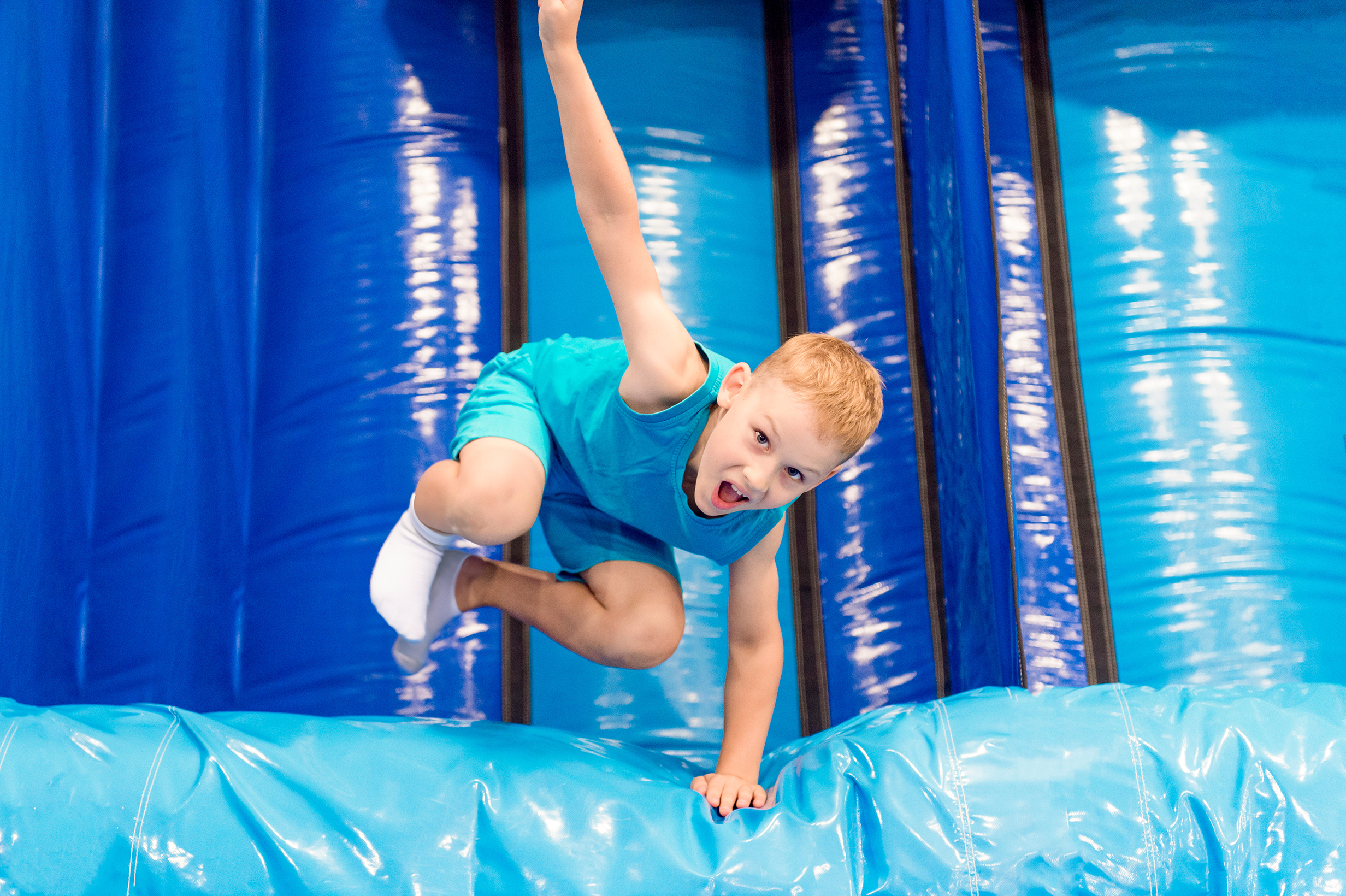 young boy jumping in a blue bounce house